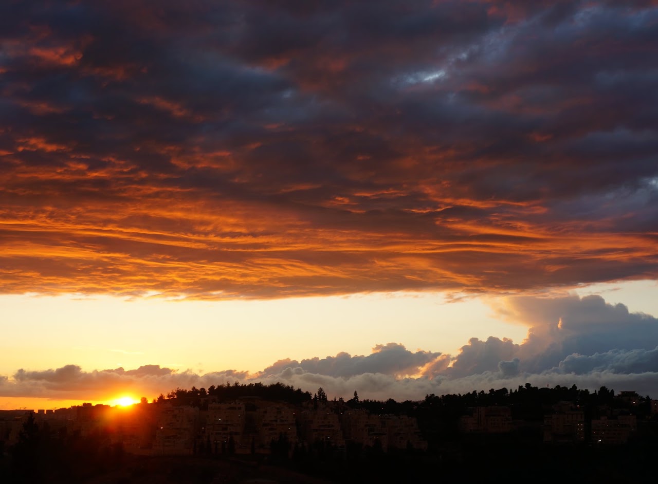 Orange sunset beneath dark clouds
